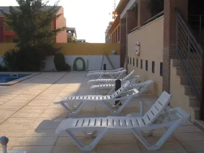 a row of white lounge chairs on a patio at Apartamento golf-mar in Vilamoura