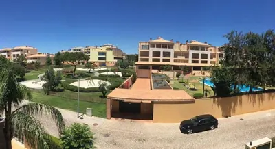 a black car parked in front of a building at Apartamento golf-mar in Vilamoura