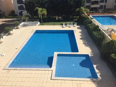 a large swimming pool sitting next to a building at Apartamento golf-mar in Vilamoura
