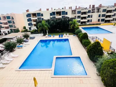 an overhead view of two swimming pools on a building at Apartamento golf-mar in Vilamoura
