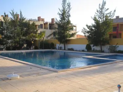 a large swimming pool in front of a building at Apartamento golf-mar in Vilamoura