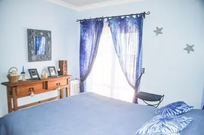 a bedroom with a blue bed and a window at Beach House in Vilamoura: Terrace+pool in Vilamoura
