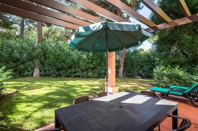 a table with a green umbrella on a patio at Quinta Golf & Beach House in Quinta do Lago