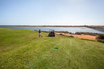 a man standing in a field with a golf ball at Quinta Golf & Beach House in Quinta do Lago