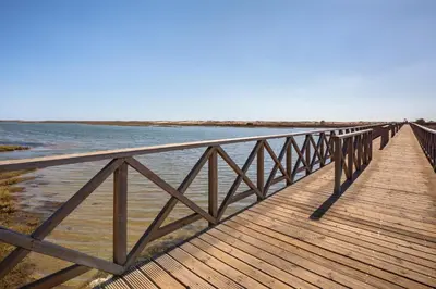 a wooden bridge over a body of water at Quinta Golf & Beach House in Quinta do Lago