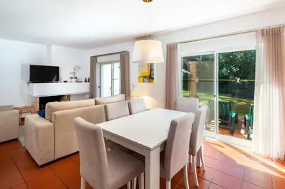 a living room with a table and a couch at Quinta Golf & Beach House in Quinta do Lago