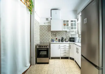 a kitchen with white cabinets and a stove at Reis Turismo 2 in Faro