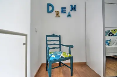 a blue chair sitting in a room with a bedroom at Blue Barqueta Studio in Faro