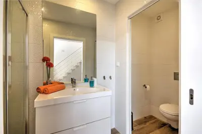 a bathroom with a sink and a toilet and a mirror at Terrace Barqueta Studio in Faro