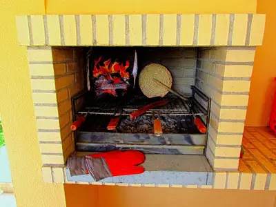 a lego fireplace with a person cooking food in it at Villa Esmeralda in Albufeira