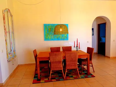 a dining room with a wooden table and chairs at Villa Esmeralda in Albufeira