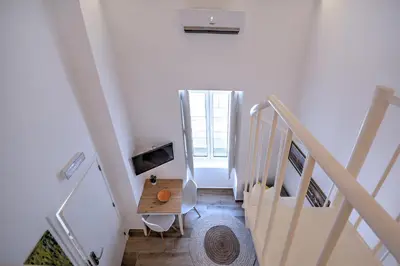 a white staircase with a table in a room at Yellow Barqueta Studio in Faro