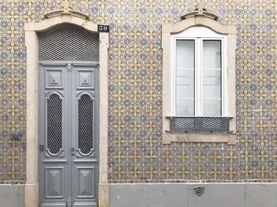 a building with a door and a window on it at Yellow Barqueta Studio in Faro