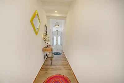 a hallway with a white wall and a rug at Yellow Barqueta Studio in Faro