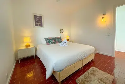 a bedroom with a bed and two lamps in it at Ria Beach House in Faro