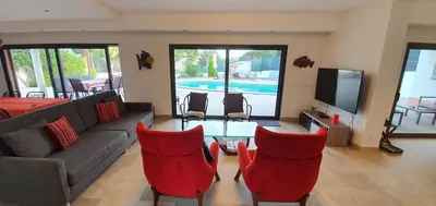 a living room with a couch and chairs and a tv at Villa Margarida by Laranjal Rentals in Albufeira