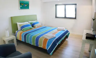 a bedroom with a bed with a colorful striped blanket at Villa Margarida by Laranjal Rentals in Albufeira