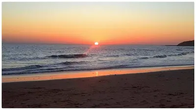 a sunset on the beach with the sun setting at Villa Margarida by Laranjal Rentals in Albufeira