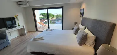 a bedroom with a large bed and a television at Villa Margarida by Laranjal Rentals in Albufeira