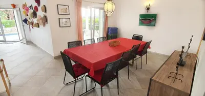 a dining room with a red table and chairs at Sunset Villa by Laranjal Rentals in Olhos de Água