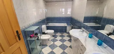 a blue and white bathroom with two toilets and a sink at Sunset Villa by Laranjal Rentals in Olhos de Água