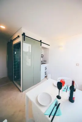 a room with a white table and a glass door at Studio Sal in Albufeira