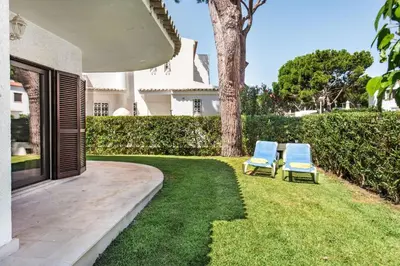 a table and chairs on a patio with a tree at Residential cul-de-sac walking distance to centre, private pool, free AC wifi in Loulé