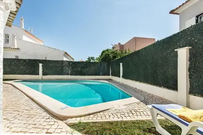 a patio with a table and a tree at Residential cul-de-sac walking distance to centre, private pool, free AC wifi in Loulé