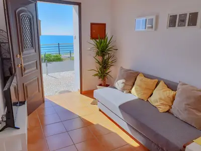 a living room with a couch and a view of the ocean at #003 Cottage By Home Holidays in Albufeira