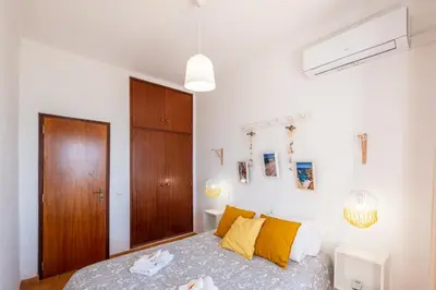 a bedroom with a bed with yellow pillows at #003 Cottage By Home Holidays in Albufeira