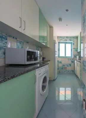 a kitchen with a washing machine and a microwave at SeaShell Apartment by Atlantic Places in Albufeira