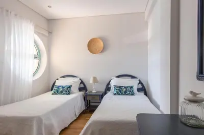 two beds in a room with a table and a window at SeaShell Apartment by Atlantic Places in Albufeira