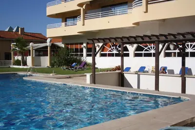 a swimming pool in front of a building at Seastar in Vilamoura