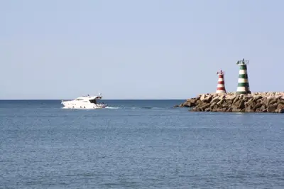 a boat in the water with two lighthouse at Seastar in Vilamoura