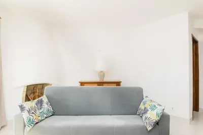a blue couch with pillows in a living room at Great S.Rafael Aprt. walking distance to the beach in Albufeira