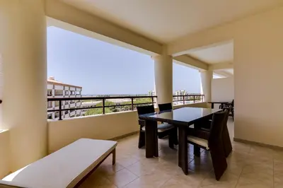 a dining room with a table and chairs on a balcony at Avelãs - Modern apartment - Vilamoura in Vilamoura