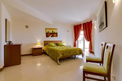 a bedroom with a bed and a chair at Avelãs - Modern apartment - Vilamoura in Vilamoura