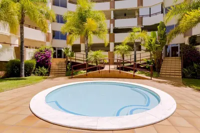an empty pool in front of a building at Avelãs - Modern apartment - Vilamoura in Vilamoura