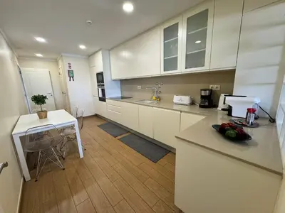 a kitchen with white cabinets and a counter top at Brisa do Mar - 2BR Sea Front Luxury Apartment in Quarteira