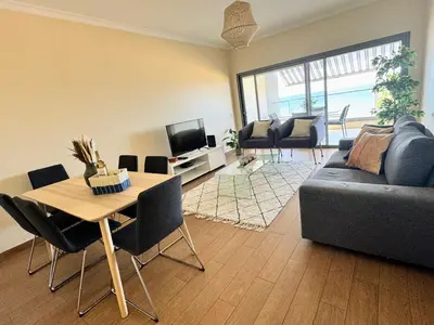 a living room with a couch and a table and chairs at Brisa do Mar - 2BR Sea Front Luxury Apartment in Quarteira