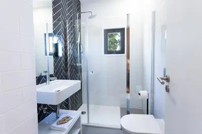 a white bathroom with a sink and a toilet at Alameda Exclusive House in Faro