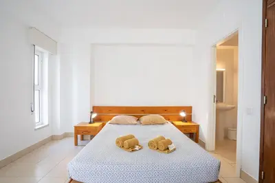 a bedroom with a bed with two pillows on it at Edifício Sequeira - Alojamento Local by Umbral in Albufeira