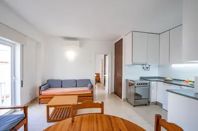 a kitchen and living room with a couch and a table at Edifício Sequeira - Alojamento Local by Umbral in Albufeira