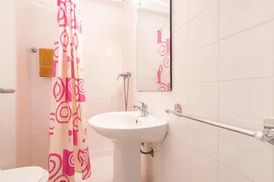 a bathroom with a sink and a toilet and a mirror at Edifício Sequeira - Alojamento Local by Umbral in Albufeira
