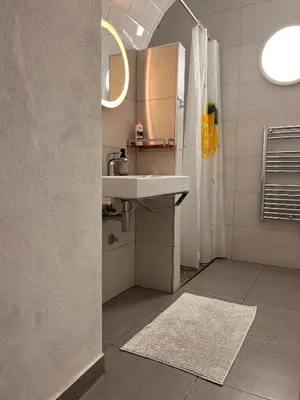 a white bathroom with a sink and a mirror at Faro Town House in Faro