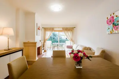 a living room with a table with a vase of flowers on it at Quinta do Paiva - Jardins do Vale in Roja- Pé