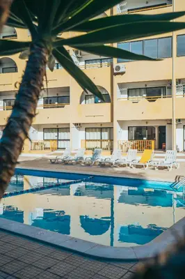 a swimming pool with lounge chairs and a building at Eirasol by Umbral in Albufeira