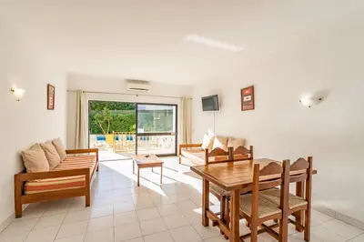 a living room with a table and chairs and a couch at Eirasol by Umbral in Albufeira
