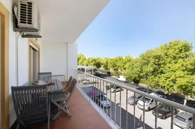 a balcony with a table and chairs and a view of a street at Golden Rana Apartment in Albufeira