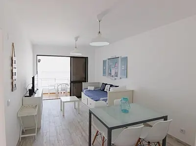 a living room with a table and a bedroom at Albufeira Apartments in Albufeira